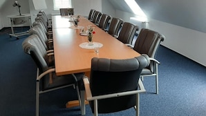 A conference room with a long table, chairs, and a whiteboard.