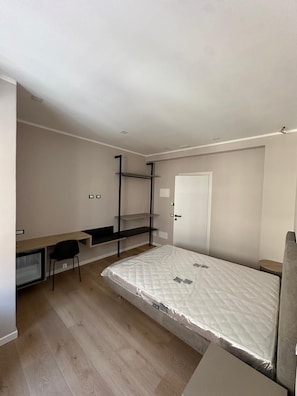 A compact room with a bed, a desk, and a chair.