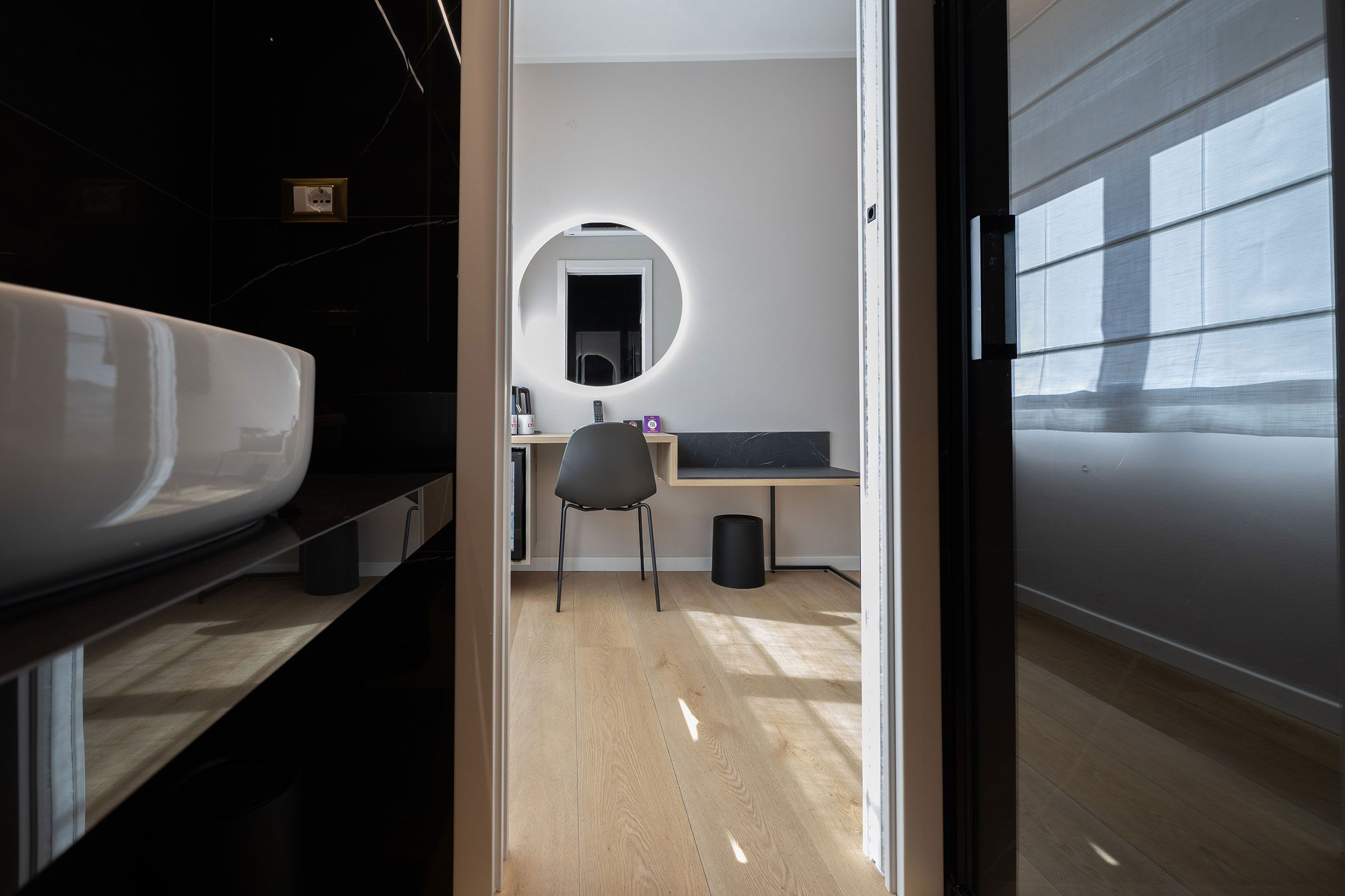 Un bagno moderno con uno specchio grande, un lavandino e un water.