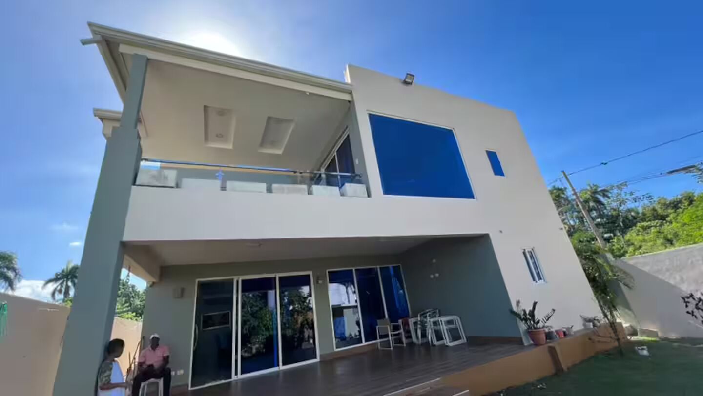 Un bâtiment à deux étages doté d’un balcon, de grandes fenêtres et d’un toit plat.