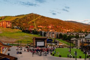 A ski resort with a large outdoor amphitheater, buildings, and a mountainous backdrop. - CW BLOCK Steamboat 3br (Steamboat Springs)