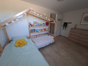 A bedroom with a bunk bed, a wooden dresser, and a shelf with books and toys. - Breton country house set in an enclosed park with century-old oak trees (Évellys)