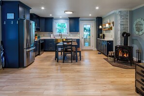 Una cocina moderna con armarios azul oscuro, electrodomésticos de acero inoxidable y una isla central con asientos.