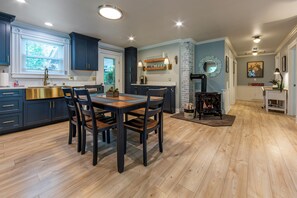 Eine moderne Küche mit dunkelblauen Schränken, einem Holztisch und einem Kamin.