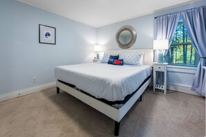 A bedroom with a bed, bedside tables, a mirror, and a window with curtains. -  Welcome to The Crooked Road Cottage at Acadia! NO cleaning fees. NO pet fees. (Bar Harbor)