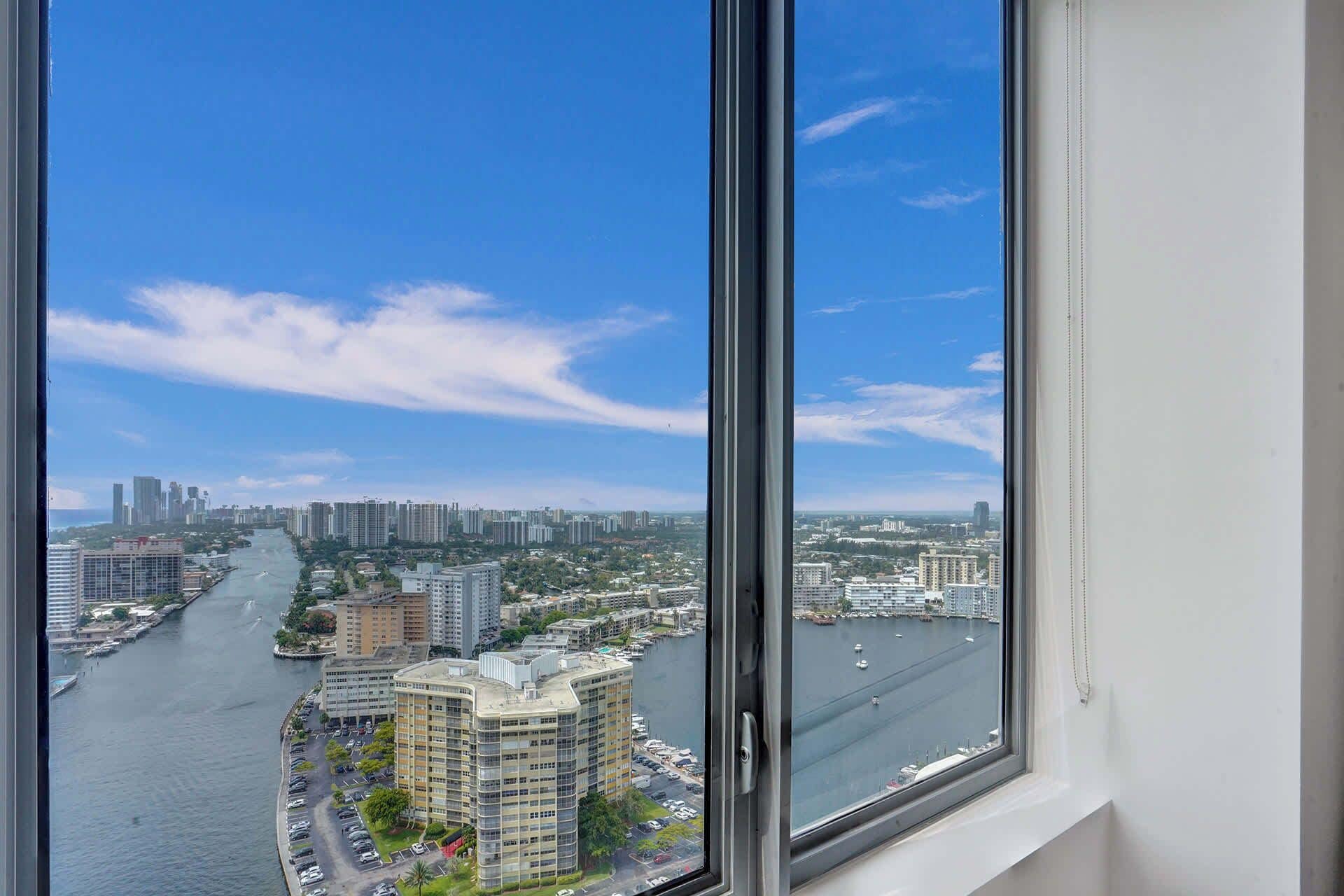 A high-rise building with a view of a river and cityscape.