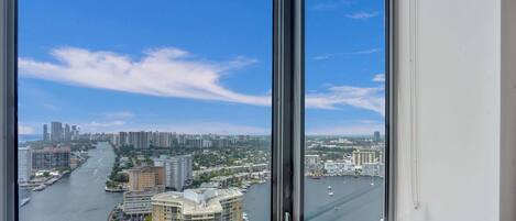 A high-rise building with a view of a river and cityscape.