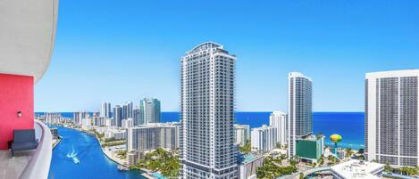 A high-rise hotel with a view of the ocean and a marina.