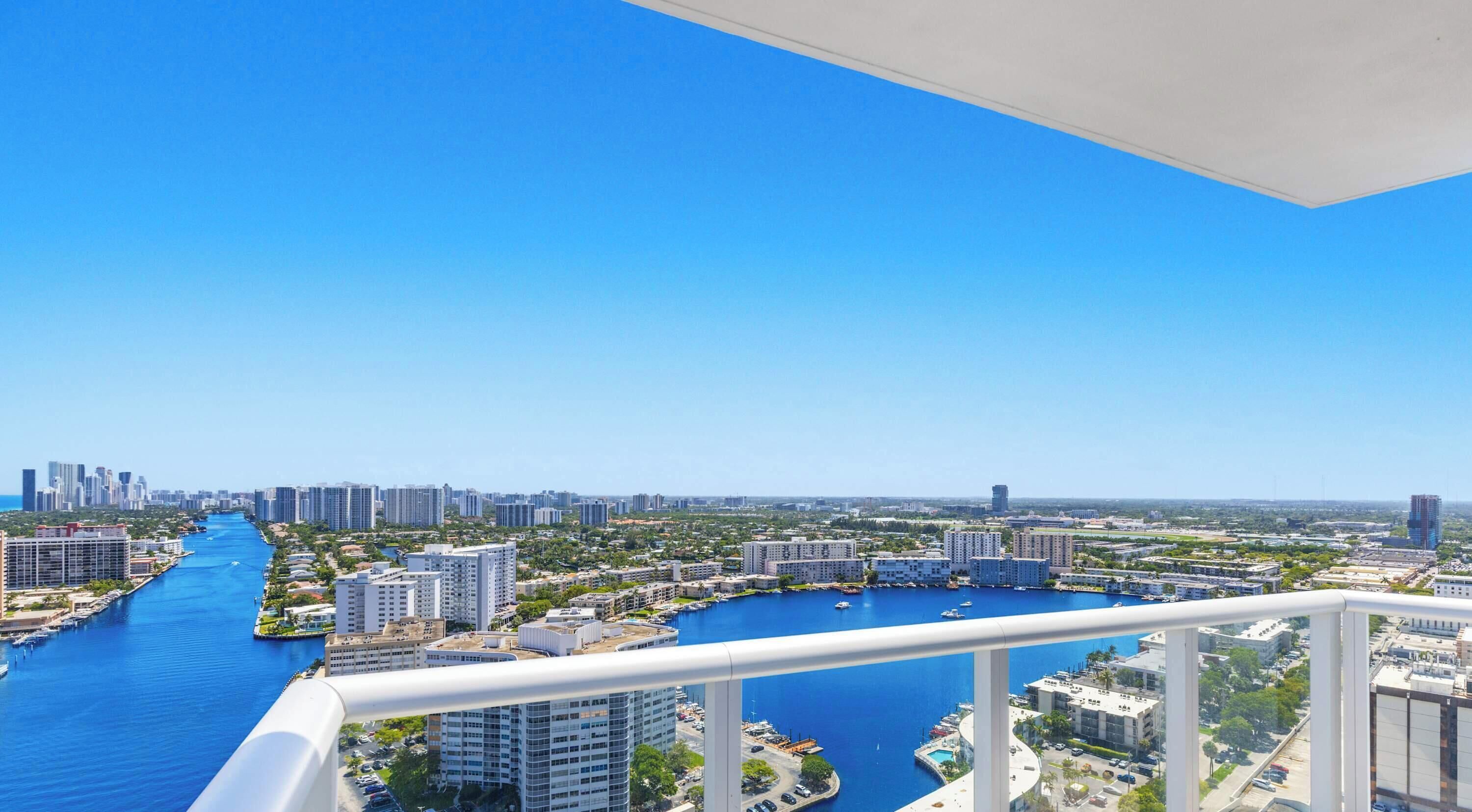 A high-rise building with a view of a river and cityscape.