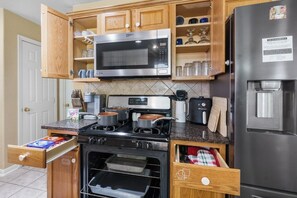 Eine Küche mit Mikrowelle, Herd, Backofen und Kühlschrank.