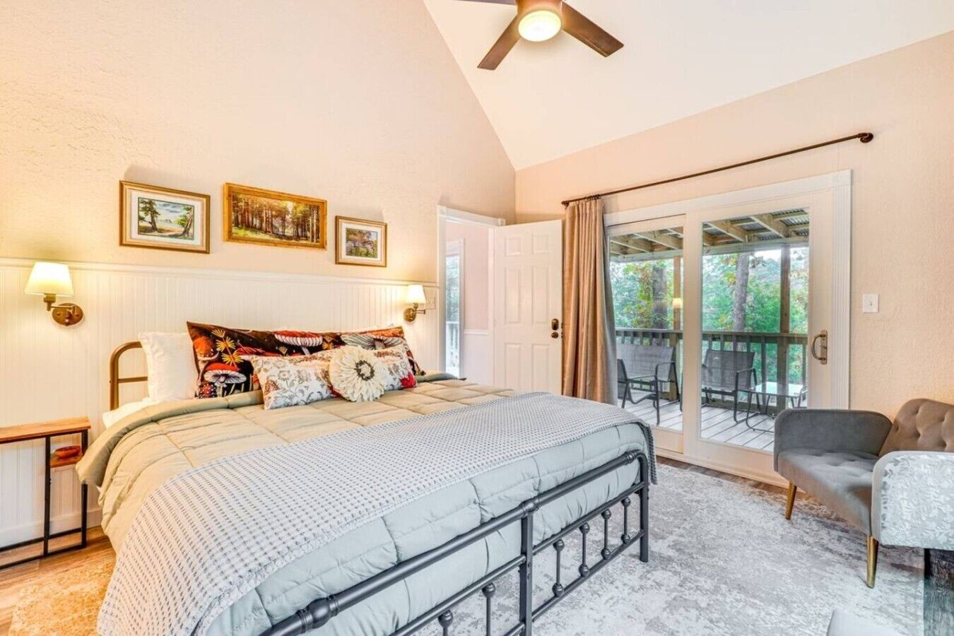 A bedroom with a bed, a nightstand, a window with curtains, and a balcony with a chair.