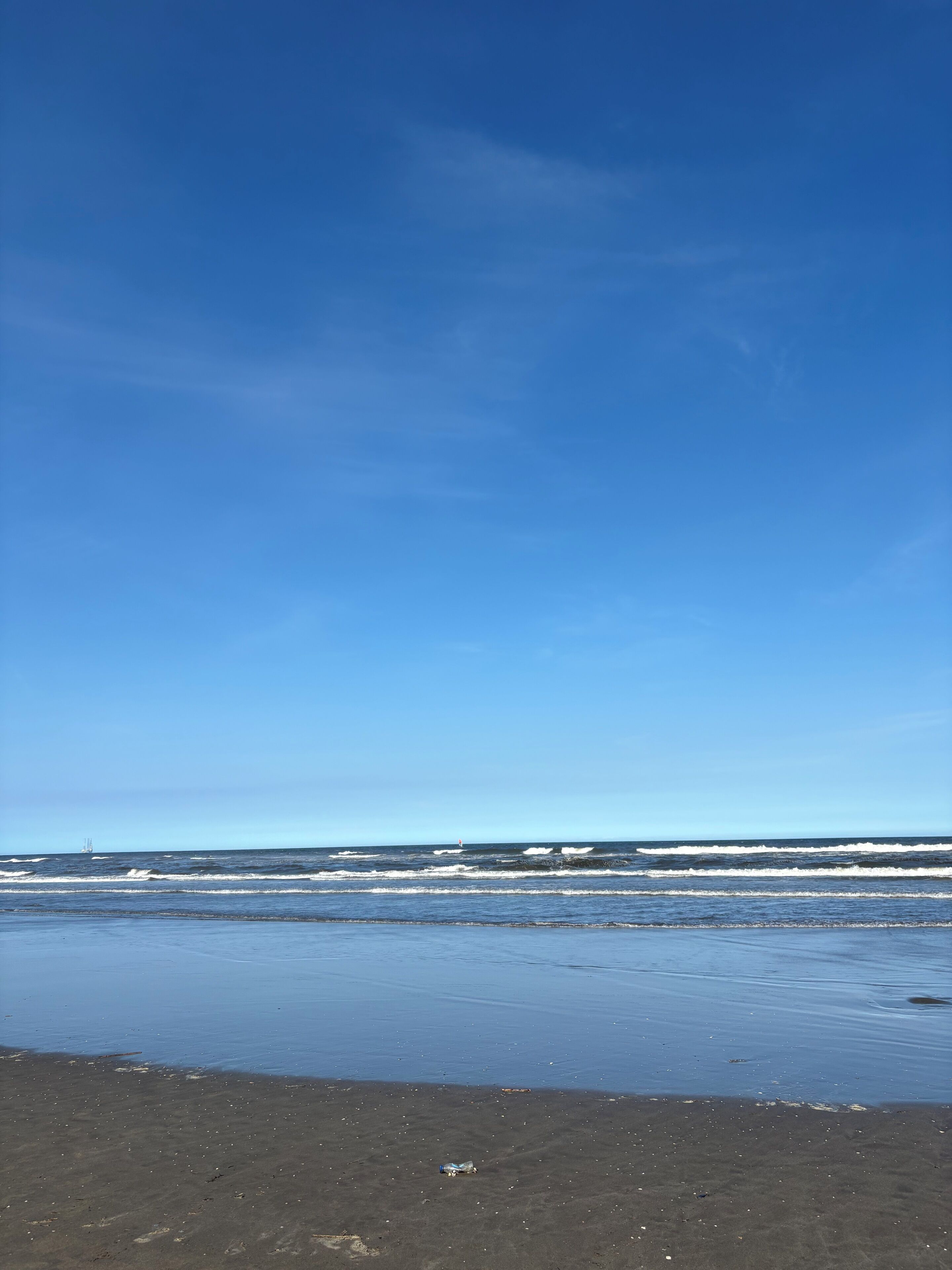A beach with a clear sky and ocean waves.