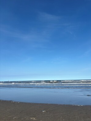 A beach with a clear sky and ocean waves.