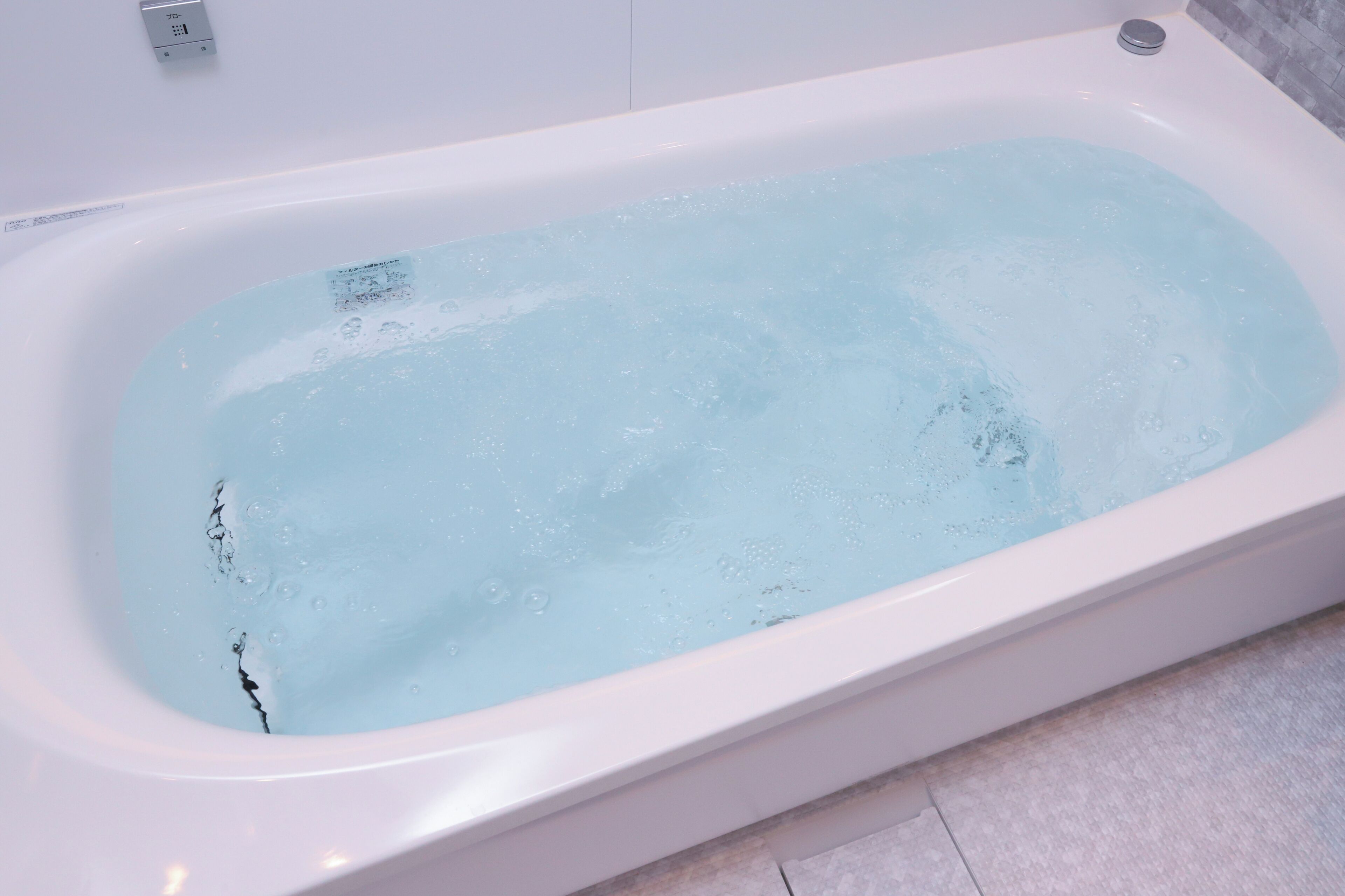 A bathtub with a faucet and a control panel.
