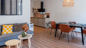 Un espace de vie moderne comprenant un canapé, une table à manger, des chaises et une petite table basse.
