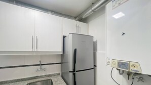 A kitchen with white cabinets, a stainless steel refrigerator, a granite countertop, and a water filtration system. - Charming Apartment in Recoleta 4 pax (Buenos Aires)