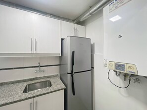 A kitchen with white cabinets, a stainless steel refrigerator, a granite countertop, and a water filtration system. - Charming Apartment in Recoleta 4 pax (Buenos Aires)