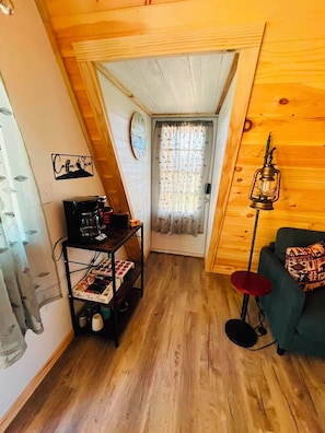 A cozy room with a wooden ceiling, a coffee machine on a cart, a red floor lamp, and a green sofa. - Newly built cabin by Luray Caverns/Shenandoah Natl Park/Wedding Venues (Stanley)