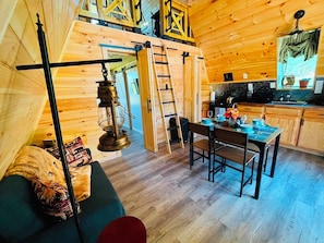 A wooden cabin interior with a dining area, a kitchen, and a loft space. - Newly built cabin by Luray Caverns/Shenandoah Natl Park/Wedding Venues (Stanley)