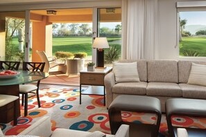 A living room with a sofa, a coffee table, and a dining area with chairs and a table. - 1 BR Shadow Ridge Villa during Coachella Music Festival (Palm Desert)