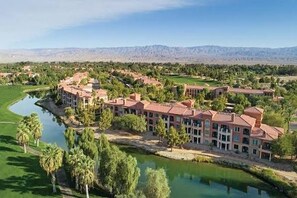 Ein Resort mit mehreren Gebäuden, einem See und einem Golfplatz.