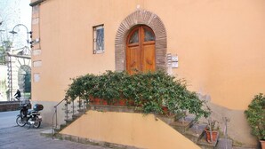 Ein Gebäude mit einer Holztür, einem kleinen Fenster und einer Treppe, die zum Eingang führt.