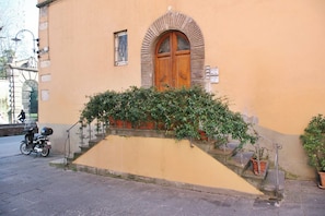 A building with a wooden door, a small window, and a staircase leading to the entrance. - Lucca: The Provincial Road. Wi-Fi, AC (Lucca)