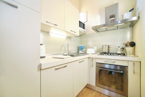 A modern kitchen with white cabinets, stainless steel appliances, and a microwave above the sink. - Lucca: The Provincial Road. Wi-Fi, AC (Lucca)