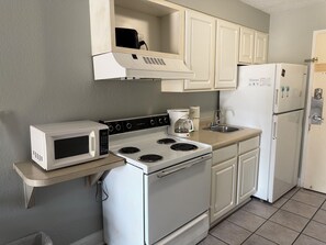 A compact kitchen with a microwave, stove, coffee maker, and refrigerator. - Your Beachfront Getaway Awaits at Myrtle Beach SC (Myrtle Beach)