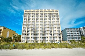 A multi-story hotel with balconies, located near a beach. - Your Beachfront Getaway Awaits at Myrtle Beach SC (Myrtle Beach)