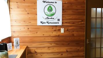 Puinen sisustus, jossa on tervetulotoivotus, vastaanottotiski ja ovi.