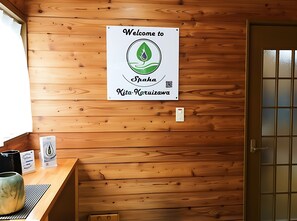 A wooden interior with a welcome sign, a reception desk, and a door.