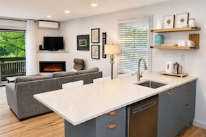 A modern kitchen with a central island, grey cabinetry, and a built-in dishwasher. - Beech Mountain Getaway with Fireplace & Views (Beech Mountain)