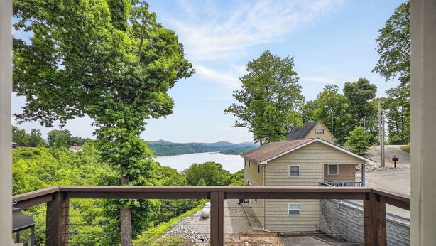 A wooden deck with a view of a lake and mountains.