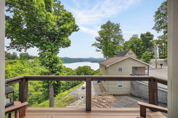 A wooden deck with a view of a lake and mountains.