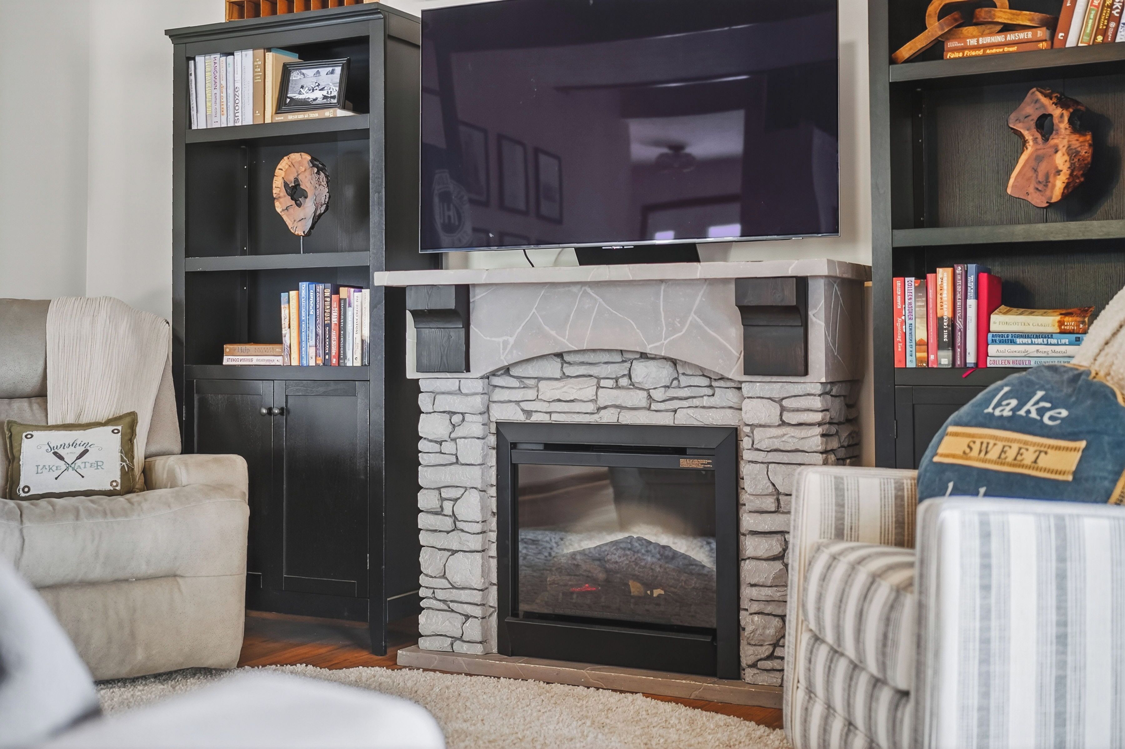 A living room with a fireplace, bookshelves, a television, and a couch.