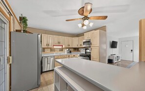 A modern kitchen with a central island, stainless steel appliances, and light wood cabinetry. - Luxury Living in one of St Louis' Most Sought-After Neighborhoods (St. Louis)
