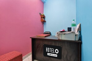 Un mostrador de recepción de hotel con un cartel que indica que es administrado por OYO.