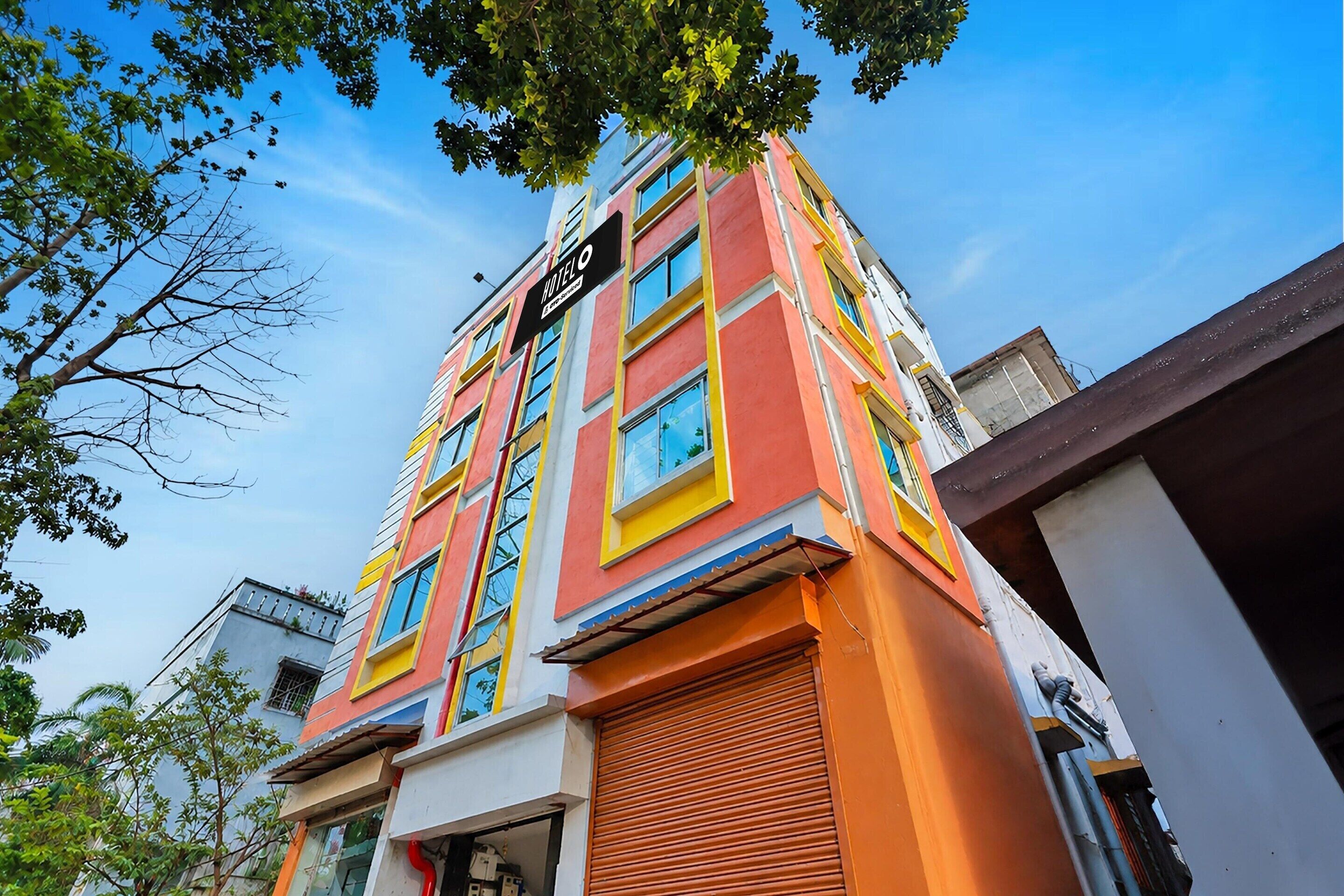 Un hotel de varios pisos con fachada colorida, grandes ventanales y un letrero que indica que es un hotel.