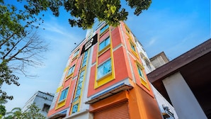 Un hotel de varios pisos con fachada colorida, grandes ventanales y un letrero que indica que es un hotel.
