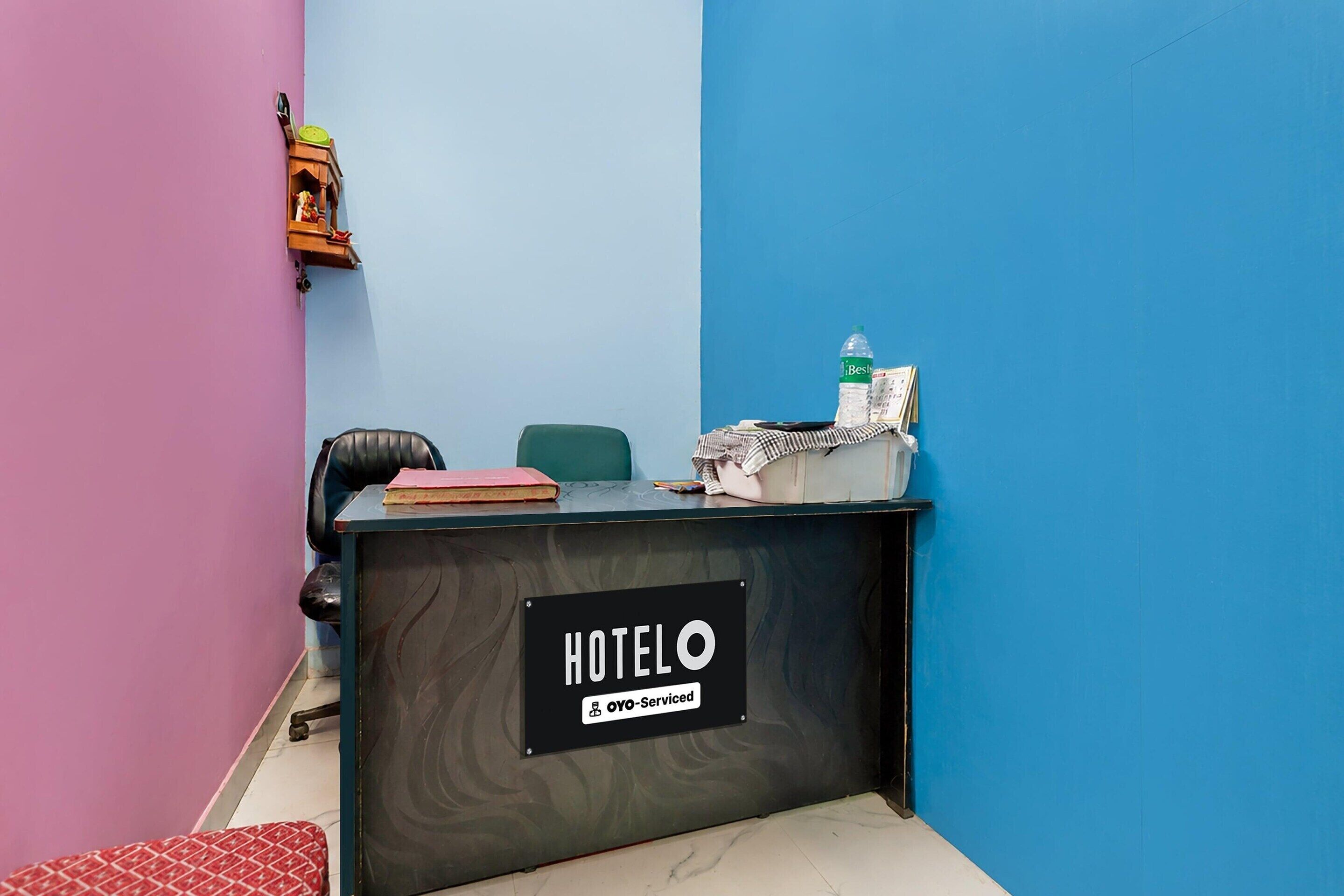 A hotel reception desk with a sign reading 'HOTEL OYO-Serviced'.