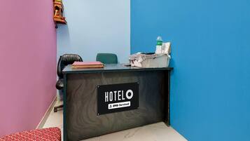A hotel reception desk with a sign reading 'HOTEL OYO-Serviced'.