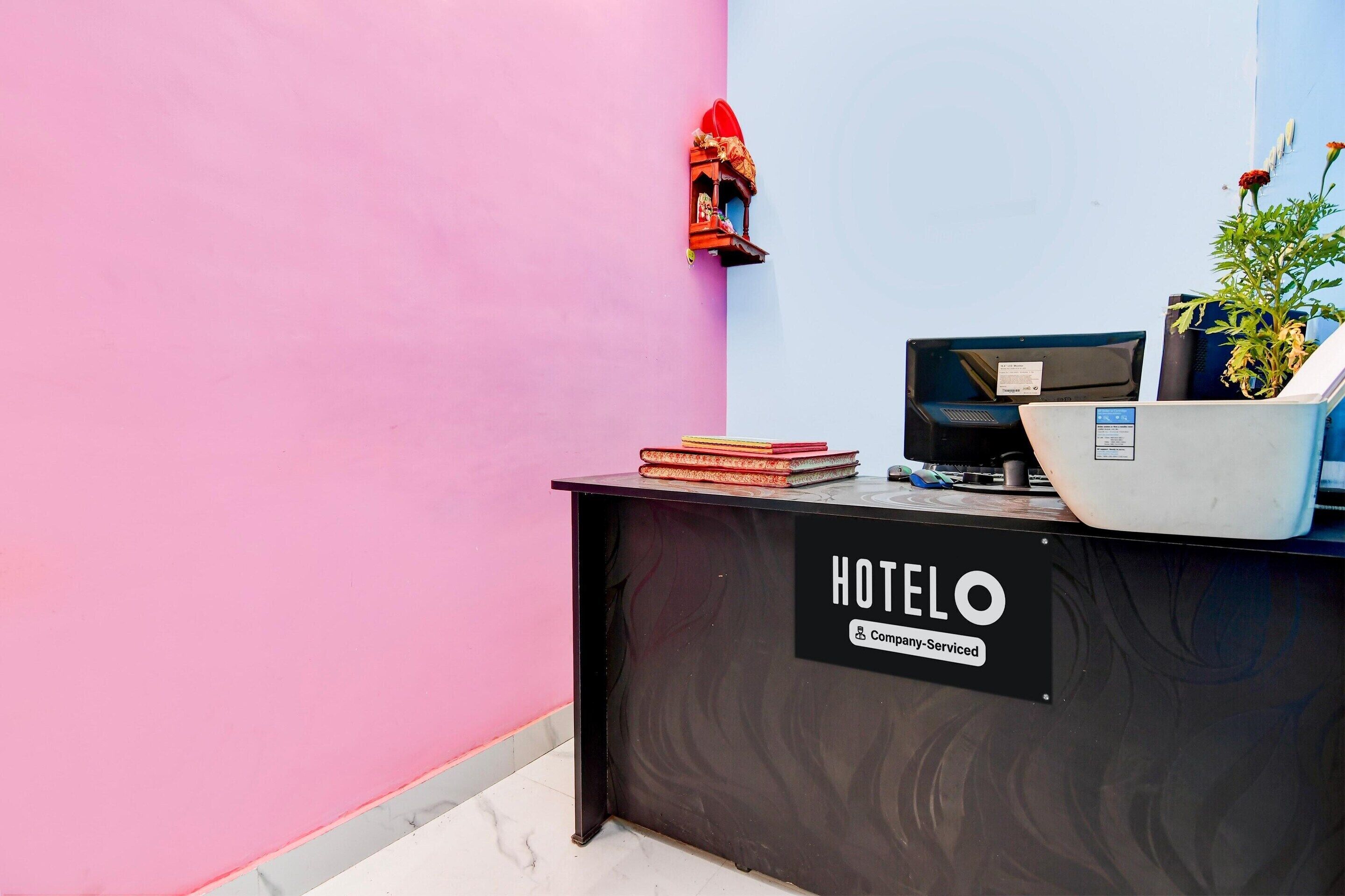 Taulell de recepció d'hotel amb un cartell que diu 'HOTELO' i una etiqueta que indica que ofereix servei d'empresa.