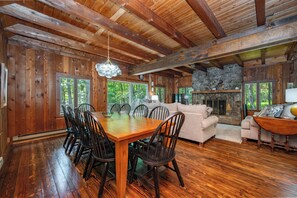 A wooden interior with a dining table, chairs, a sofa, and a fireplace. - New! Lake Front Home w/ Private Dock! (Swanton)