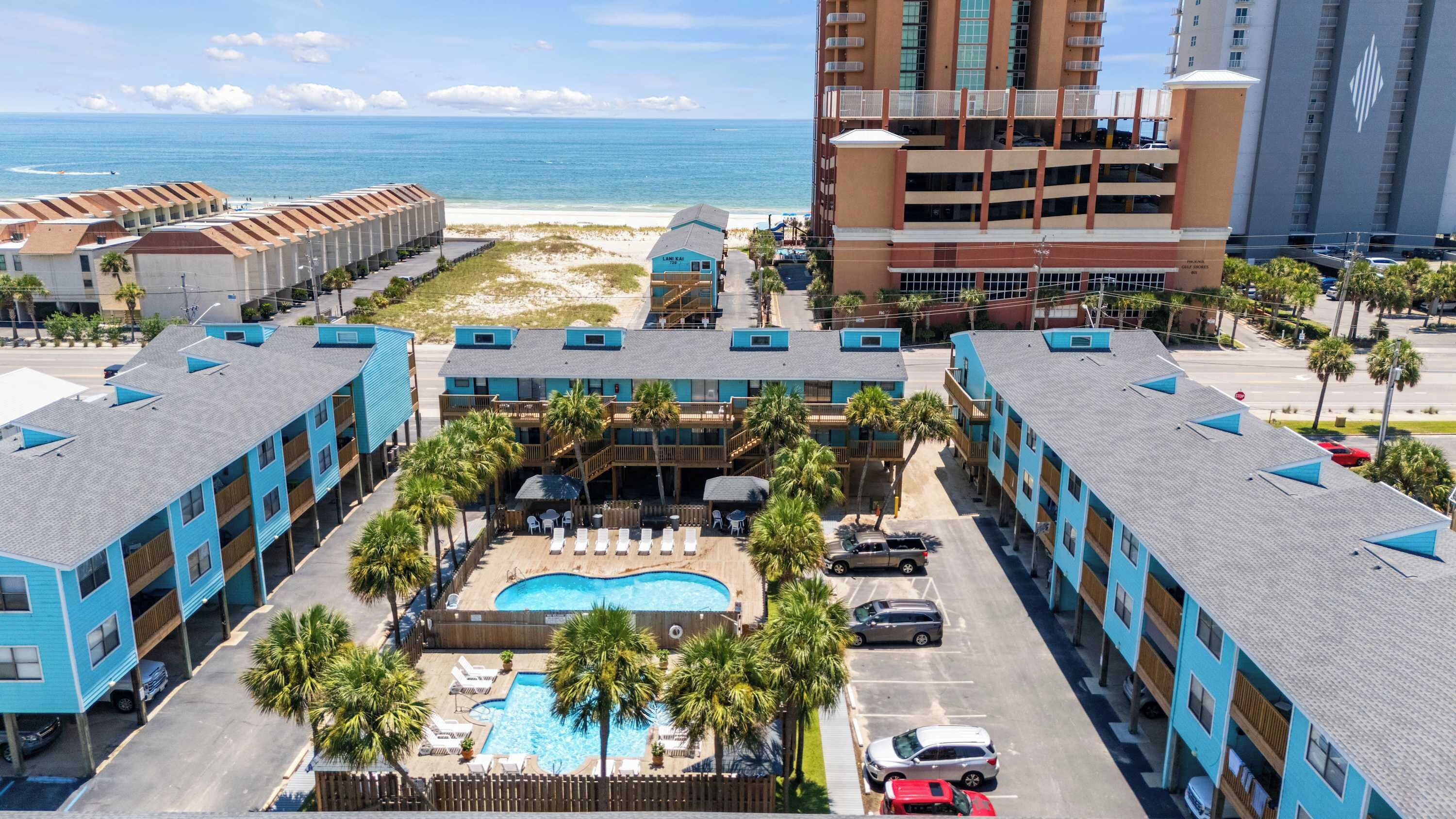 Un hôtel doté d’une piscine, offrant une vue sur la plage et comprenant plusieurs bâtiments.