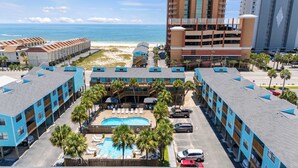 A hotel with a pool, beach view, and multiple buildings. - Poolside Condo with Beach Access (Gulf Shores)