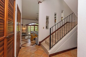 Ein geräumiger Flur mit Treppe, Holztüren und einem Essbereich im Hintergrund.