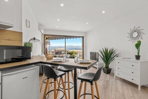 Eine moderne Küche mit Essbereich, Blick auf das Meer und einem großen Fenster.
