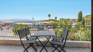 A balcony with a view of a marina, parked cars, and a clear sky. - Apartment Le Mistral by Sur la mer (Saint Raphael)