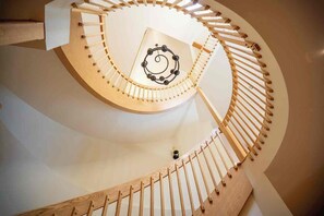Una escala en espiral amb barana de fusta i un disseny circular al centre.